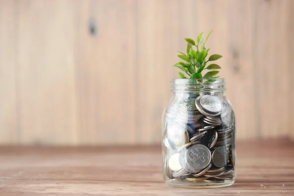 Plant growing from jar of coins